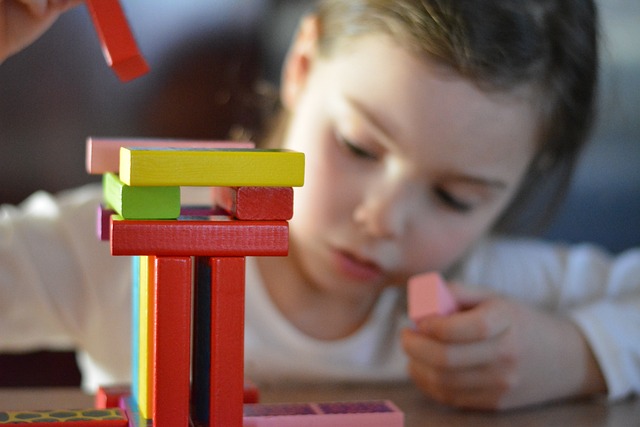 niño concentrado jugando a construccion de madera